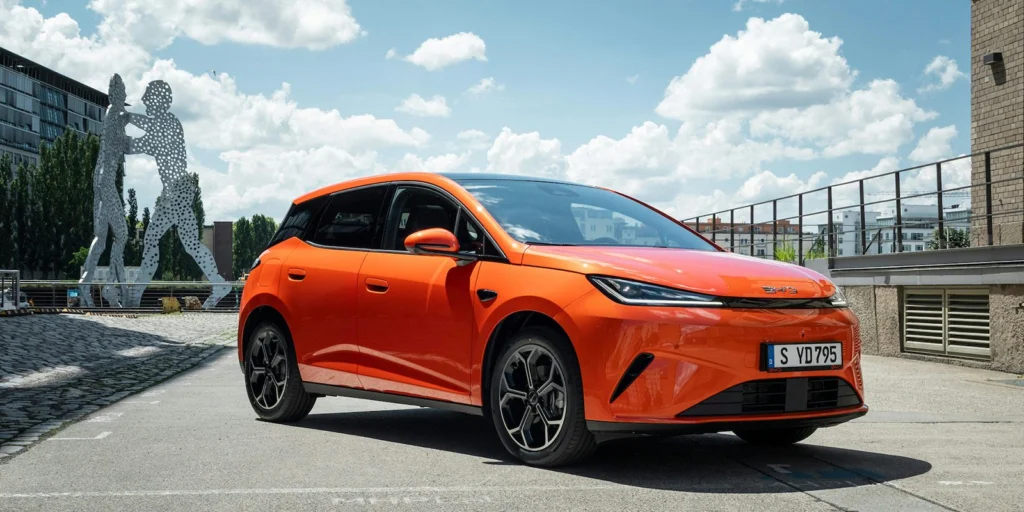 Oranžové BYD Dolphin G DM-i parkuje v meste